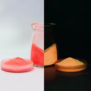 Pigmento fotoluminiscente EVERYGLOW que brilla con un tono rojo neón naranja intenso.